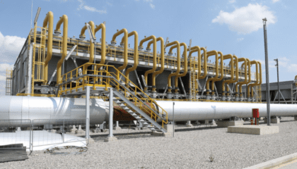 An image of some pipework that performs part of the Trans Adriatic Pipeline in Southern Europe. The pipe work is silver and yellow, and also features a set of steps up to the pipework facility